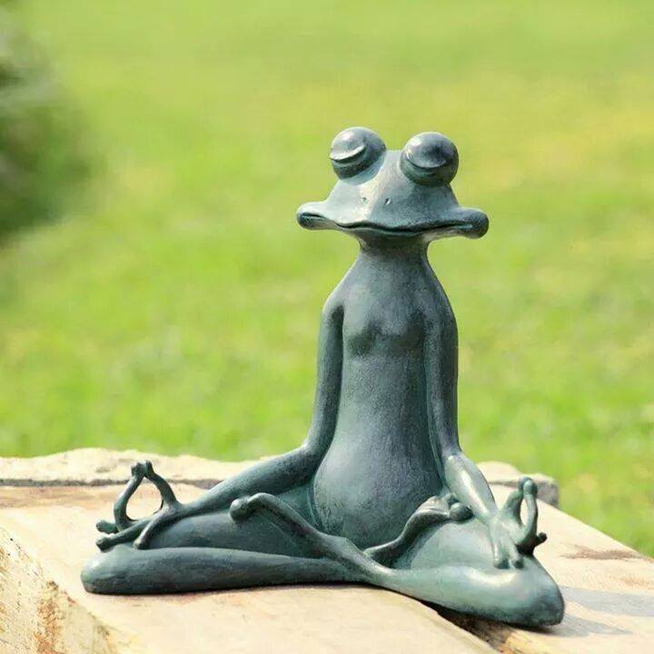 Une sculpture d'une grenouille assise en lotus, en train de méditer